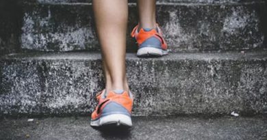 A person jogging along a scenic trail with a backdrop of lush greenery, highlighting the benefits of daily exercise and physical activity for improved health and well-being.
